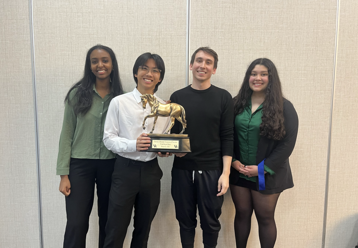 Shining Trophies and Smiles
Leah Ghebrelul, Preston Nguyen, Andy Stubbs, and Erica Carranza pose for a picture after the final round of TOC. With a 1-4 decision in favor of Greenhill High School, second place was secured. "Never lose faith in yourself, work so hard you can't fail," Nguyen said.